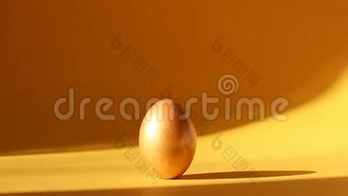 黄色背景阳光下的金色复活节彩蛋